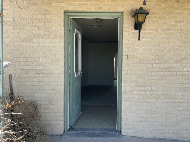 entrance to property featuring brick siding