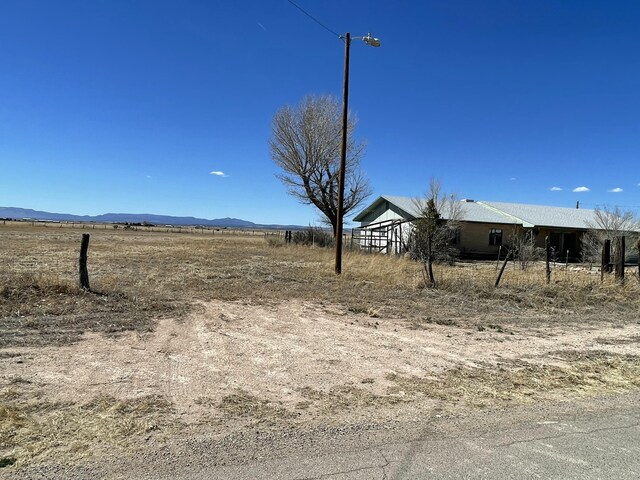 view of yard with a rural view and a mountain view