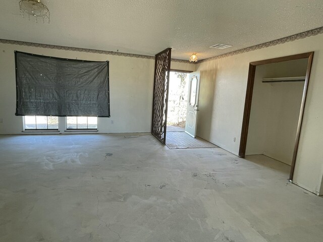 unfurnished bedroom with visible vents, unfinished concrete floors, and a textured ceiling