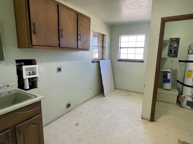 laundry area with hookup for an electric dryer, a textured ceiling, strapped water heater, cabinet space, and light floors