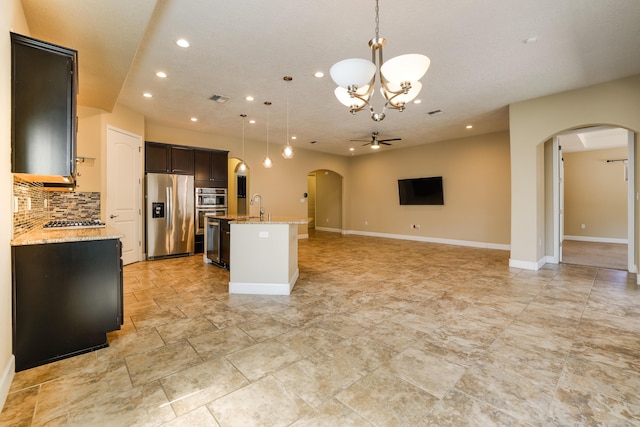 kitchen with appliances with stainless steel finishes, recessed lighting, ceiling fan with notable chandelier, and arched walkways