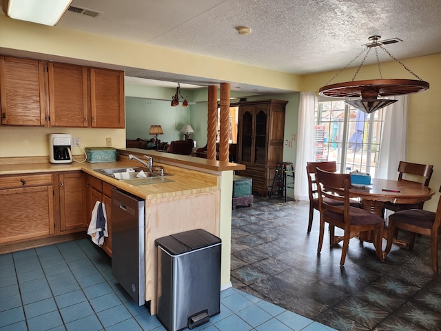 404 Pyrite Dr NE, Rio Rancho, NM 87124 - kitchen with a sink, stainless steel dishwasher, a peninsula, light countertops, and dark tile patterned floors