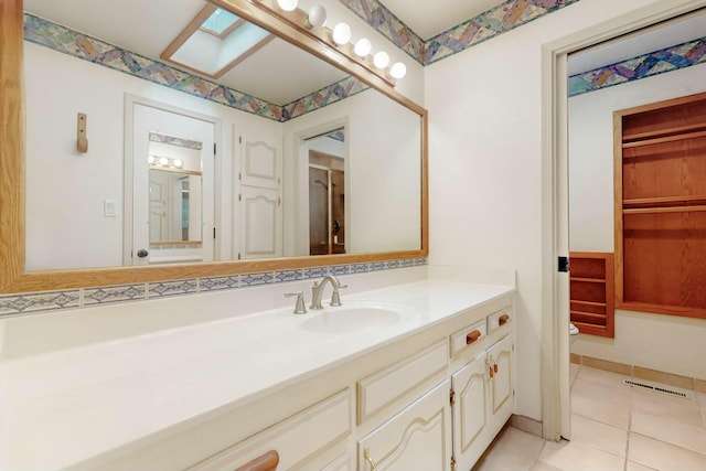 7827 Academy Trl NE, Albuquerque, NM 87109 - bathroom featuring tile patterned flooring, vanity, toilet, and a skylight