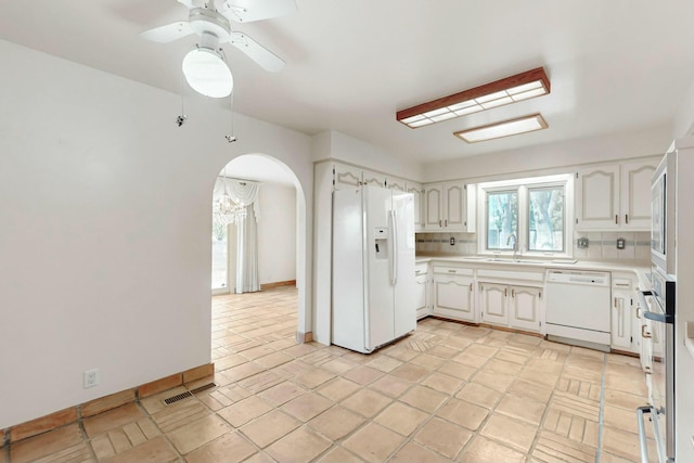 7827 Academy Trl NE, Albuquerque, NM 87109 - kitchen with white appliances, arched walkways, a sink, a ceiling fan, and light countertops