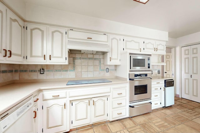 7827 Academy Trl NE, Albuquerque, NM 87109 - kitchen featuring appliances with stainless steel finishes, a warming drawer, backsplash, under cabinet range hood, and light countertops