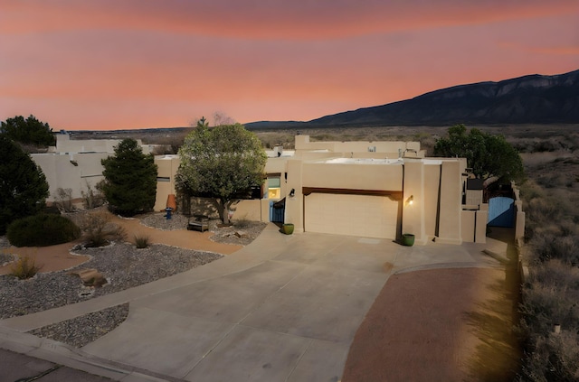 2544 Sandia Loop NE, Rio Rancho, NM 87144 - adobe home featuring a garage, a mountain view, stucco siding, and driveway
