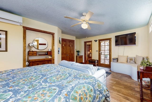 2544 Sandia Loop NE, Rio Rancho, NM 87144 - bedroom featuring ceiling fan, an AC wall unit, a textured ceiling, wood finished floors, and a closet