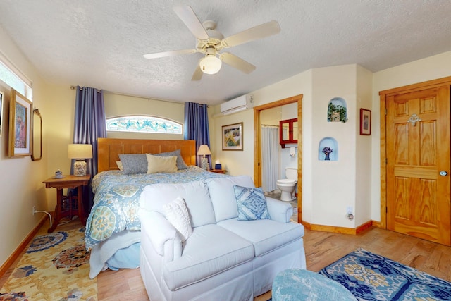 2544 Sandia Loop NE, Rio Rancho, NM 87144 - bedroom with a textured ceiling, baseboards, a wall mounted air conditioner, and wood finished floors