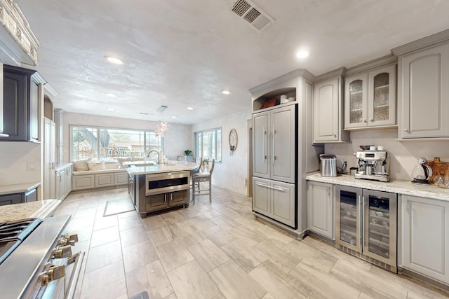kitchen with high end stainless steel range, beverage cooler, visible vents, and recessed lighting