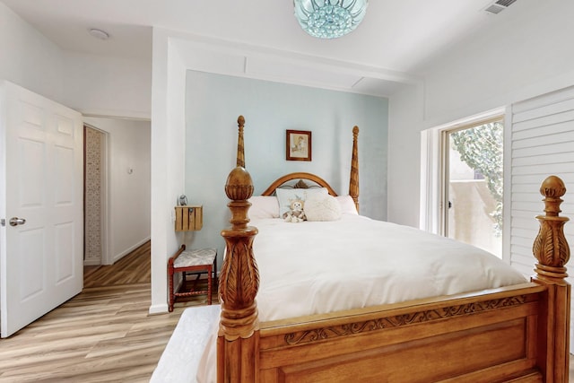 bedroom featuring baseboards, access to outside, light wood finished floors, and visible vents