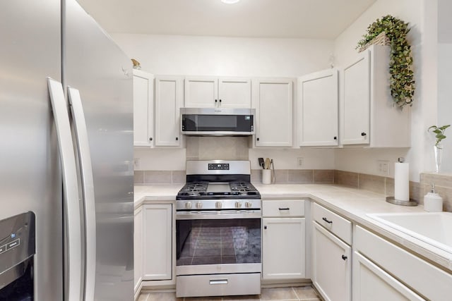 kitchen featuring light countertops, a sink, white cabinets, and appliances with stainless steel finishes