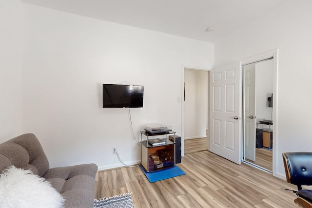 living area featuring baseboards and light wood finished floors