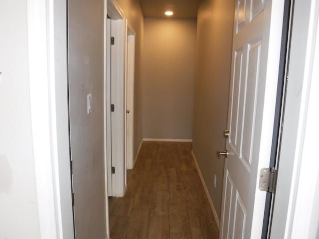 hallway with baseboards, recessed lighting, and dark wood finished floors