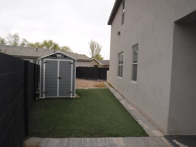 view of yard featuring a storage shed, a fenced backyard, and an outdoor structure