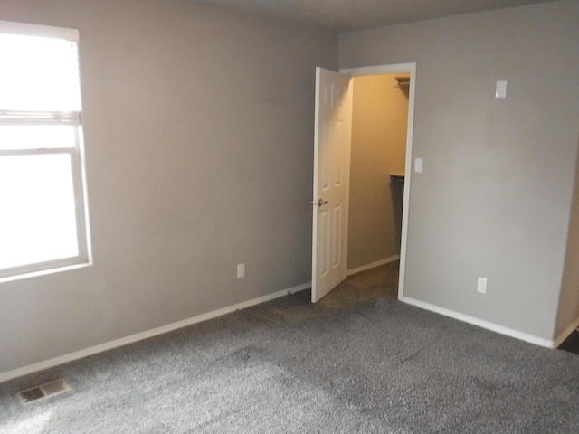 carpeted empty room with baseboards and visible vents