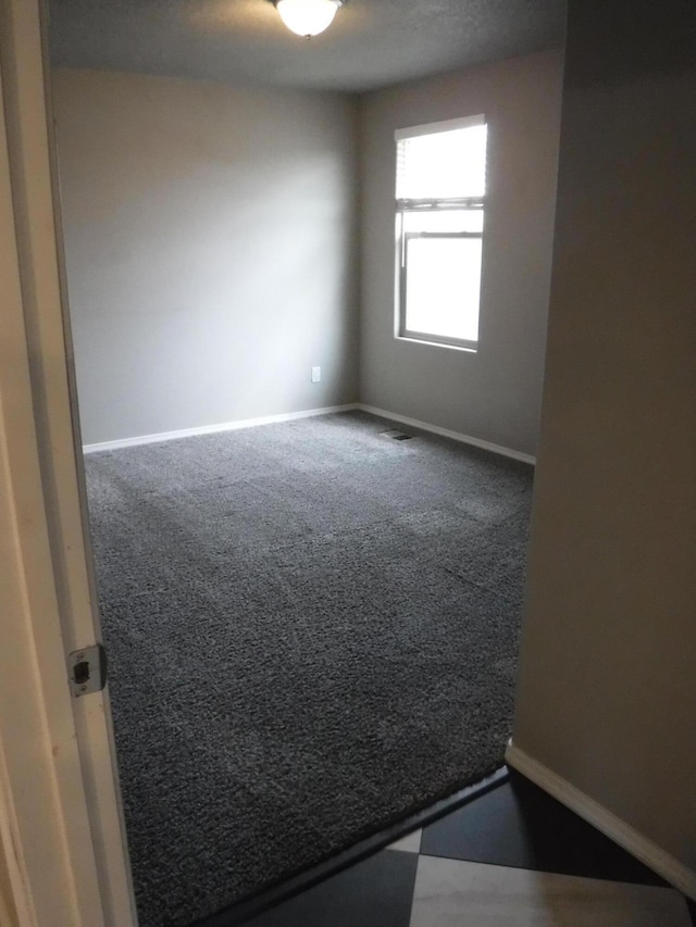 unfurnished room with baseboards and carpet floors