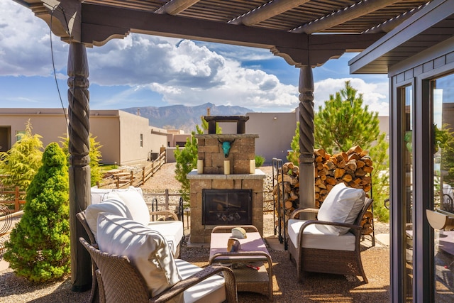 view of patio / terrace with a pergola, a mountain view, and an outdoor living space with a fireplace