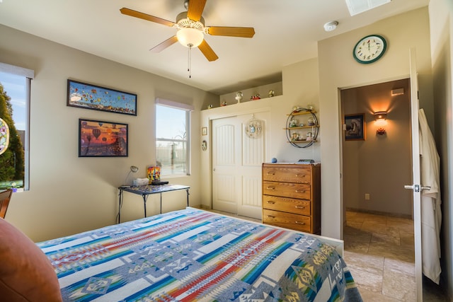bedroom with stone finish flooring, visible vents, a closet, and ceiling fan