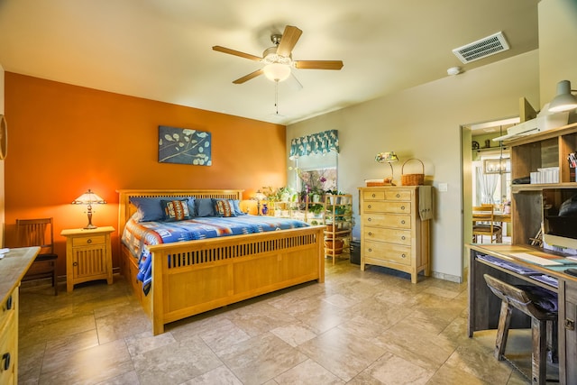 bedroom with visible vents, stone tile floors, and a ceiling fan