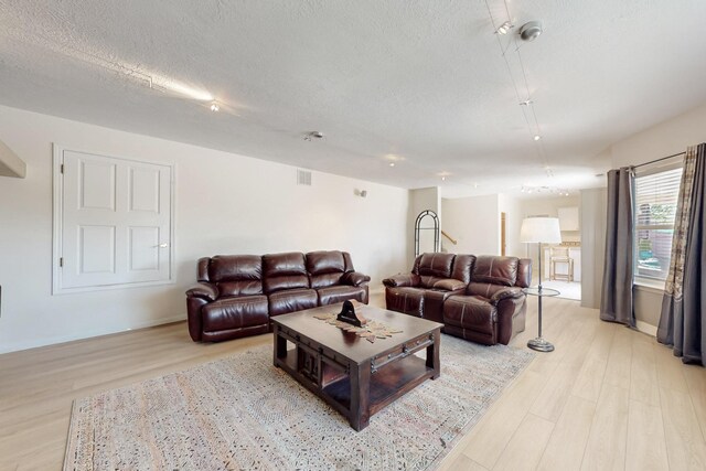 4104 Killington Rd NW, Albuquerque, NM 87114 - living room featuring light wood-style floors, a textured ceiling, and baseboards