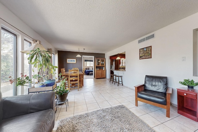 5208 Simon Dr NW, Albuquerque, NM 87114 - living room featuring visible vents, a textured ceiling, and light tile patterned floors