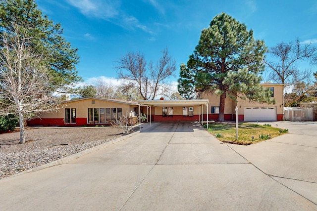 5208 Simon Dr NW, Albuquerque, NM 87114 - view of front of property with stucco siding, an attached carport, and concrete driveway