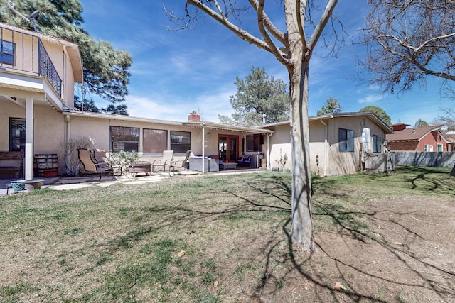 5208 Simon Dr NW, Albuquerque, NM 87114 - back of house with a lawn, a patio area, fence, outdoor lounge area, and stucco siding
