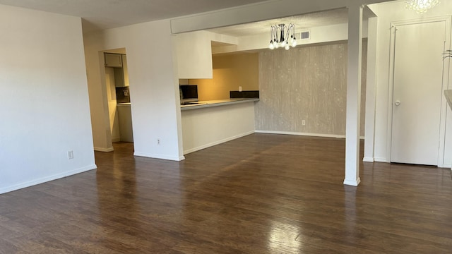 3839 Montgomery Blvd NE Unit 724, Albuquerque, NM 87109 - unfurnished living room featuring dark wood finished floors, baseboards, visible vents, and an inviting chandelier