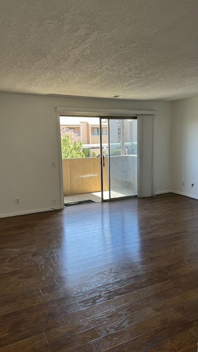 3839 Montgomery Blvd NE Unit 724, Albuquerque, NM 87109 - spare room featuring baseboards, a textured ceiling, and dark wood-style floors