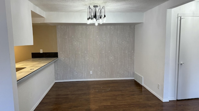 3839 Montgomery Blvd NE Unit 724, Albuquerque, NM 87109 - unfurnished dining area with a textured ceiling, visible vents, baseboards, wood finished floors, and an inviting chandelier