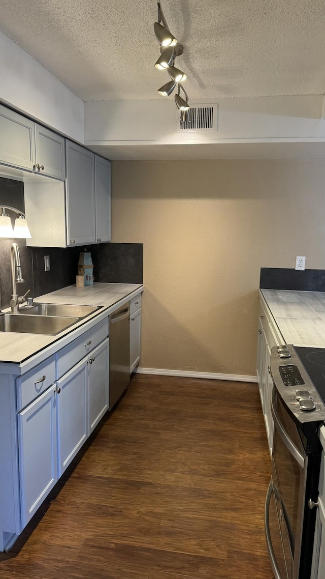 3839 Montgomery Blvd NE Unit 724, Albuquerque, NM 87109 - kitchen featuring a sink, stainless steel appliances, baseboards, visible vents, and dark wood-style flooring