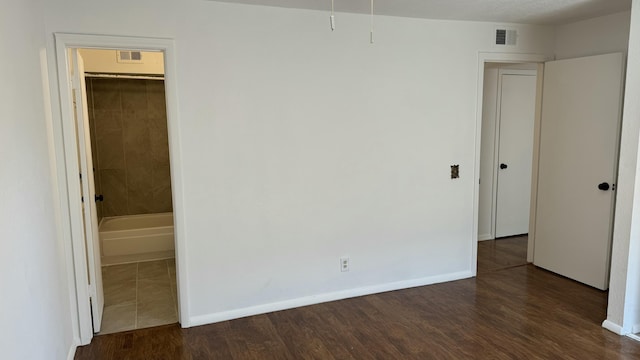 3839 Montgomery Blvd NE Unit 724, Albuquerque, NM 87109 - unfurnished bedroom featuring dark wood-style floors, visible vents, and baseboards