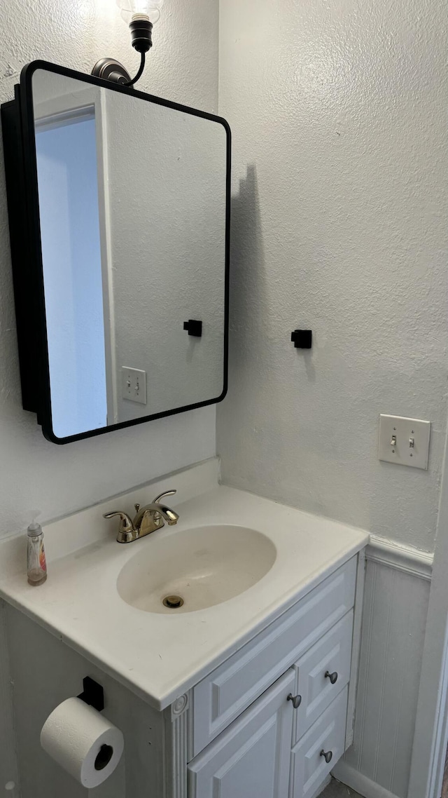 3839 Montgomery Blvd NE Unit 724, Albuquerque, NM 87109 - bathroom featuring a decorative wall, vanity, a textured wall, and wainscoting