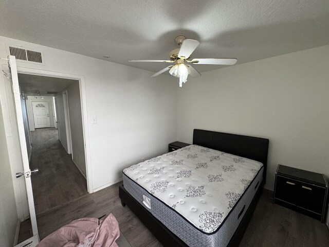 4601 Carlisle Blvd NE Unit E1, Albuquerque, NM 87109 - bedroom featuring a textured ceiling, visible vents, ceiling fan, and dark wood-style flooring