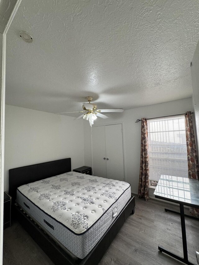 4601 Carlisle Blvd NE Unit E1, Albuquerque, NM 87109 - bedroom with a closet, a textured ceiling, ceiling fan, and wood finished floors