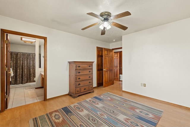 69 Midway Rd, Lemitar, NM 87823 - bedroom featuring light wood-style flooring, baseboards, a ceiling fan, and ensuite bathroom
