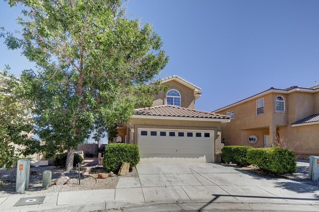 4844 Stafford Pl NW, Albuquerque, NM 87120 - mediterranean / spanish-style home with driveway, stucco siding, a tile roof, and a garage