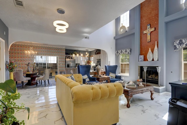 4844 Stafford Pl NW, Albuquerque, NM 87120 - living room with marble finish floor, a glass covered fireplace, a chandelier, and visible vents