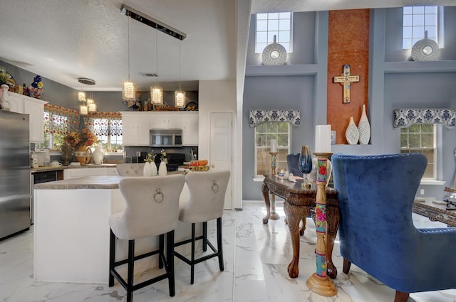 4844 Stafford Pl NW, Albuquerque, NM 87120 - kitchen featuring a textured ceiling, visible vents, white cabinets, marble finish floor, and stainless steel appliances