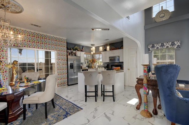 4844 Stafford Pl NW, Albuquerque, NM 87120 - kitchen with a breakfast bar area, marble finish floor, visible vents, white cabinets, and appliances with stainless steel finishes