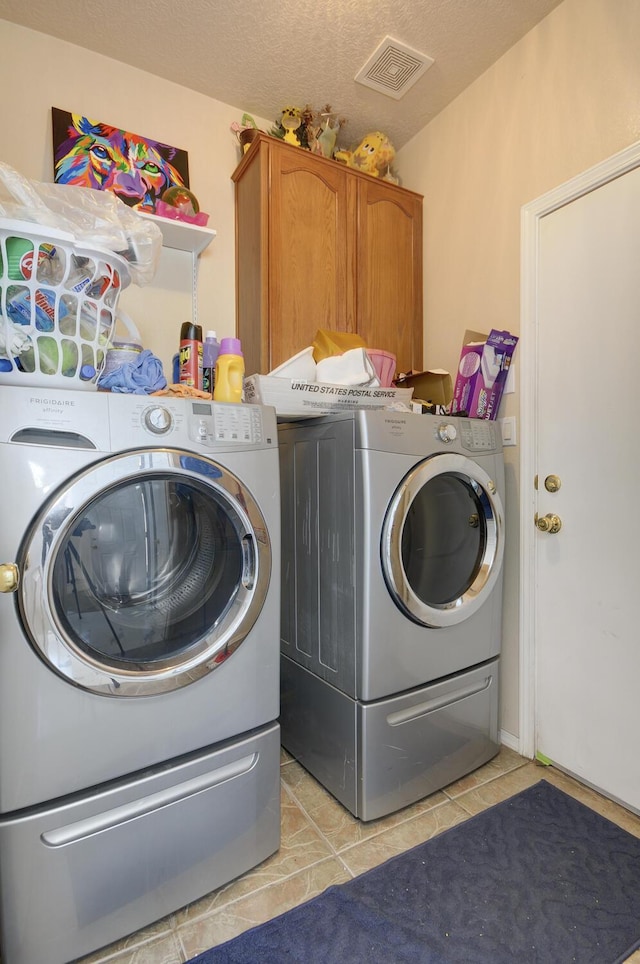 4844 Stafford Pl NW, Albuquerque, NM 87120 - laundry room featuring washer and clothes dryer, light tile patterned floors, a textured ceiling, visible vents, and cabinet space