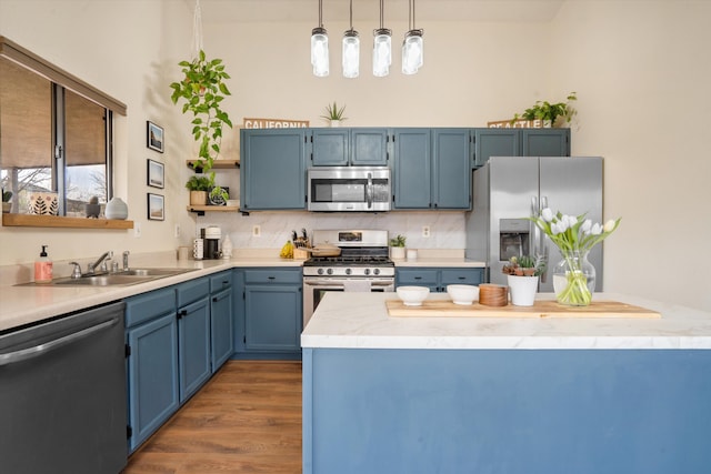 6624 Conrad Ave NW, Albuquerque, NM 87120 - kitchen with open shelves, a sink, pendant lighting, blue cabinetry, and appliances with stainless steel finishes
