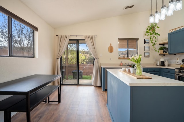 6624 Conrad Ave NW, Albuquerque, NM 87120 - kitchen with open shelves, light wood-style floors, light countertops, blue cabinetry, and visible vents