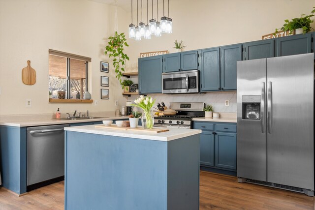 6624 Conrad Ave NW, Albuquerque, NM 87120 - kitchen featuring light countertops, blue cabinets, a high ceiling, and stainless steel appliances