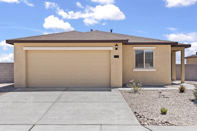 2518 Desi Loop, Belen, NM 87002 - view of front facade featuring a garage, roof with shingles, driveway, and stucco siding