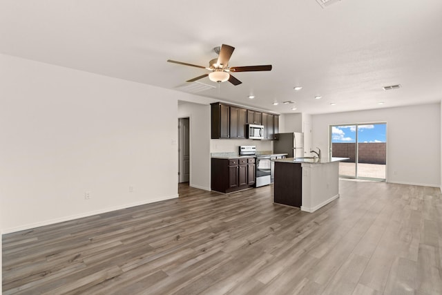 2518 Desi Loop, Belen, NM 87002 - kitchen featuring open floor plan, a kitchen island with sink, visible vents, and stainless steel appliances