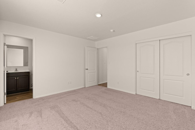 2518 Desi Loop, Belen, NM 87002 - unfurnished bedroom featuring a closet, baseboards, ensuite bathroom, a sink, and carpet floors