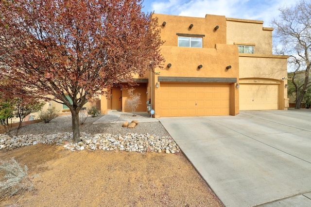 2467 Corvara Dr SE, Rio Rancho, NM 87124 - pueblo revival-style home with stucco siding, a garage, and concrete driveway