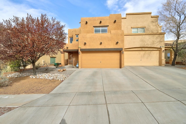 2467 Corvara Dr SE, Rio Rancho, NM 87124 - adobe home with concrete driveway, stucco siding, and a garage