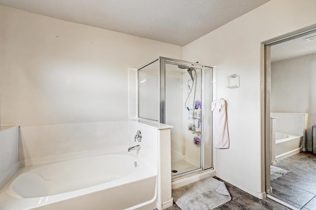2467 Corvara Dr SE, Rio Rancho, NM 87124 - full bathroom featuring a garden tub, a stall shower, a textured ceiling, and baseboards